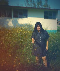 Portrait of young woman standing on field