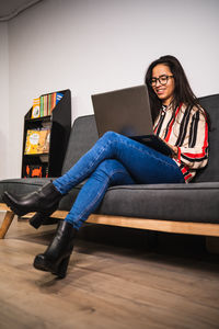 Full length of woman using laptop while sitting at office