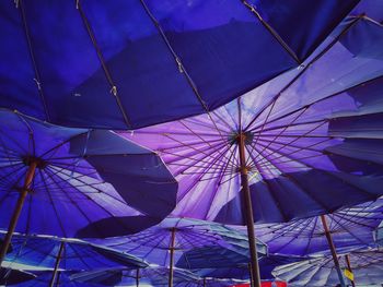 Low angle view of umbrella against blue sky