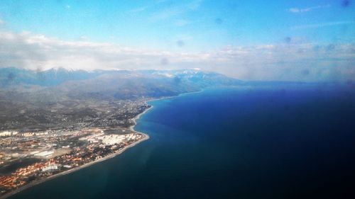 Aerial view of sea and mountains against sky