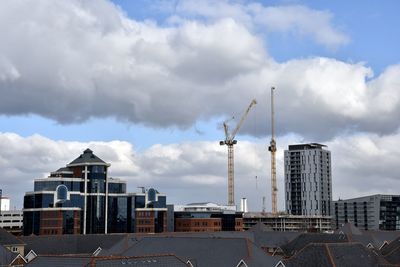 Construction site in city against sky