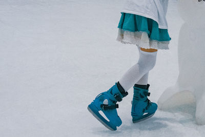 Low section of person wearing shoes on snow