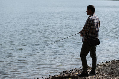 Man fishing at sea shore