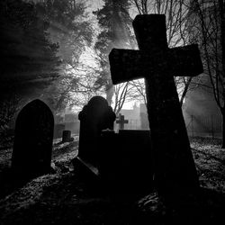 Close-up of cross in cemetery against sky