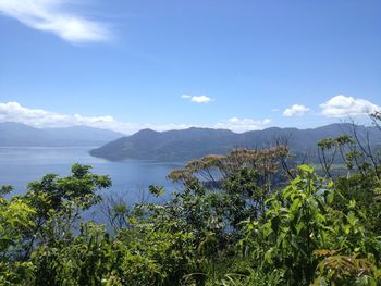 Scenic view of sea and mountains against sky