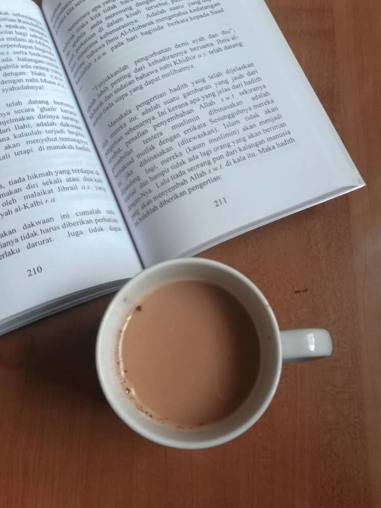 HIGH ANGLE VIEW OF COFFEE CUP ON BOOK