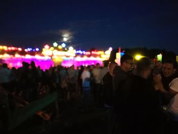 Crowd at music concert against sky at night