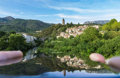 Reflection of trees and buildings on mountain against sky