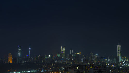 Illuminated buildings against sky at night