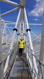 Rear view of men on bridge against sky