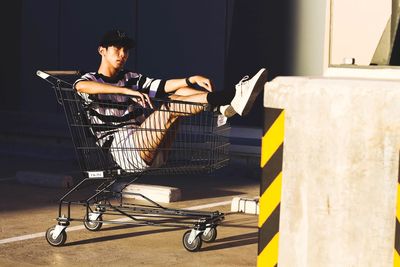 Man sitting in shopping cart