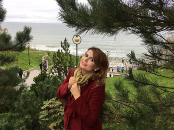 Portrait of woman shivering while standing by trees