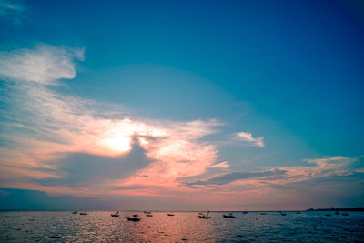 Beautiful sunrise on sea background with tropical wooden fishing boat