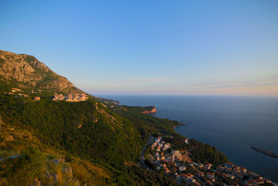 Scenic view of sea and mountains against blue sky