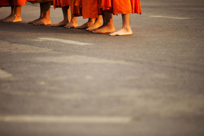 Cropped image of monks standing on road