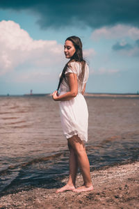 Full length of young woman standing on beach