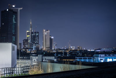 Illuminated buildings in city against sky at night