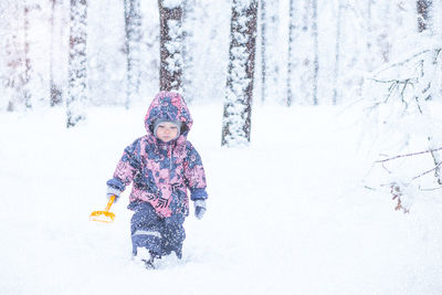 Full length of cute baby girl on snow covered land