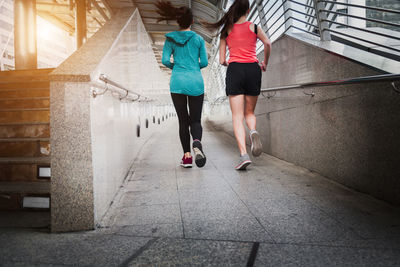 Rear view of women walking on footpath