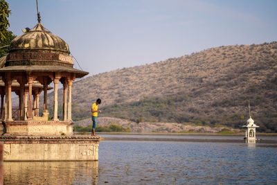 Rear view of man looking at temple against building