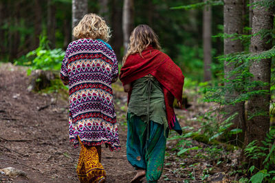 Rear view of women walking in forest