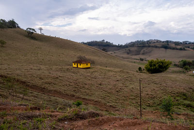 Scenic view of road amidst field against sky