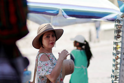 Portrait of woman wearing hat standing outdoors