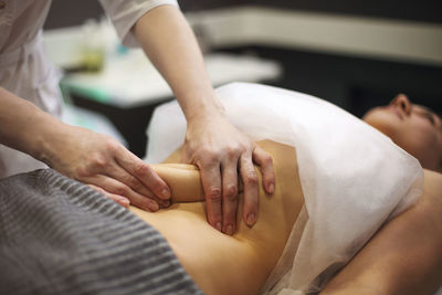 Midsection of therapist massaging woman