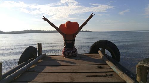 Woman in sea against sky