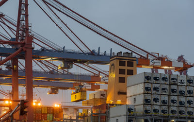 Low angle view of crane at construction site against sky