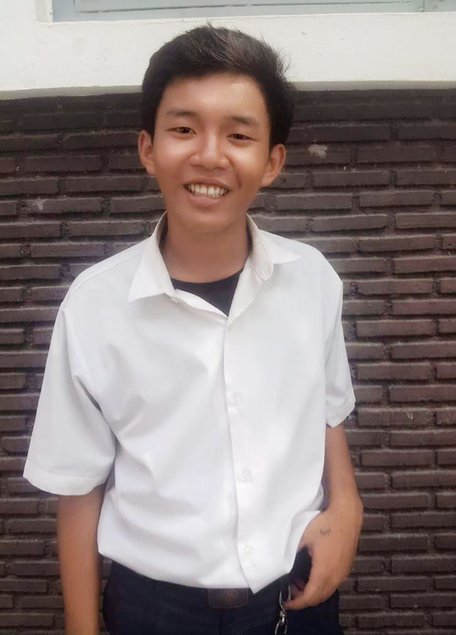 PORTRAIT OF YOUNG MAN STANDING ON WALL