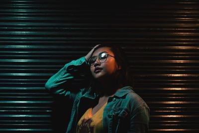 Portrait of fashionable young woman against shutter