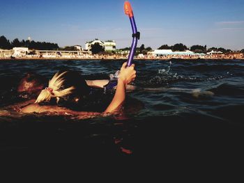 Midsection of woman in sea against sky