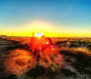 Scenic view of field against clear sky during sunset