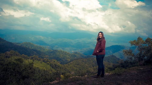 Woman standing on mountain against sky