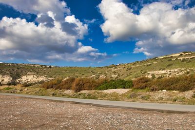 Road leading towards mountains against sky