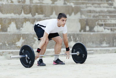 Weightlifter lifting weights in an urban environment.