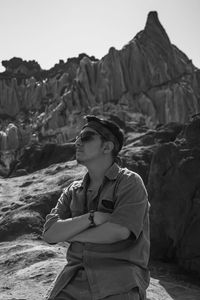 Portrait of young man standing against mountain