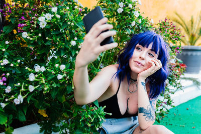 Photo of adorable young woman making selfie outdoors backyard