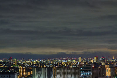 Illuminated buildings in city against sky at night