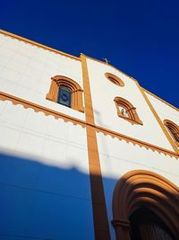 Low angle view of building against clear blue sky