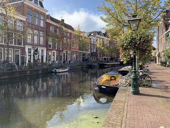 Boats in canal by buildings in city
