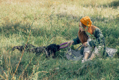 Side view of woman with dog on field