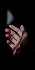 Close-up of human hand against black background