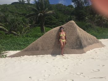 Rear view of woman lying down on land against trees