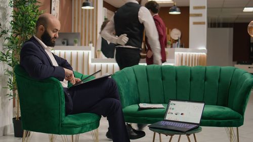 Side view of woman using laptop while sitting in cafe