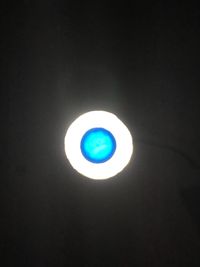 Illuminated light against moon at night
