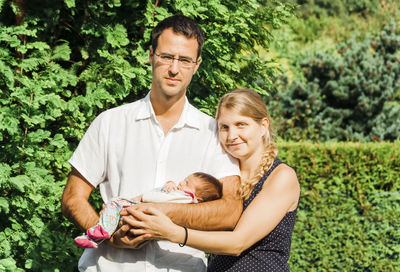 Portrait of happy family standing against plants