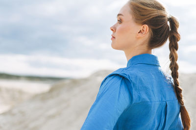 Side view of young woman looking at sea shore