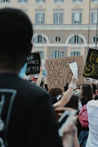 Rear view of people standing against building